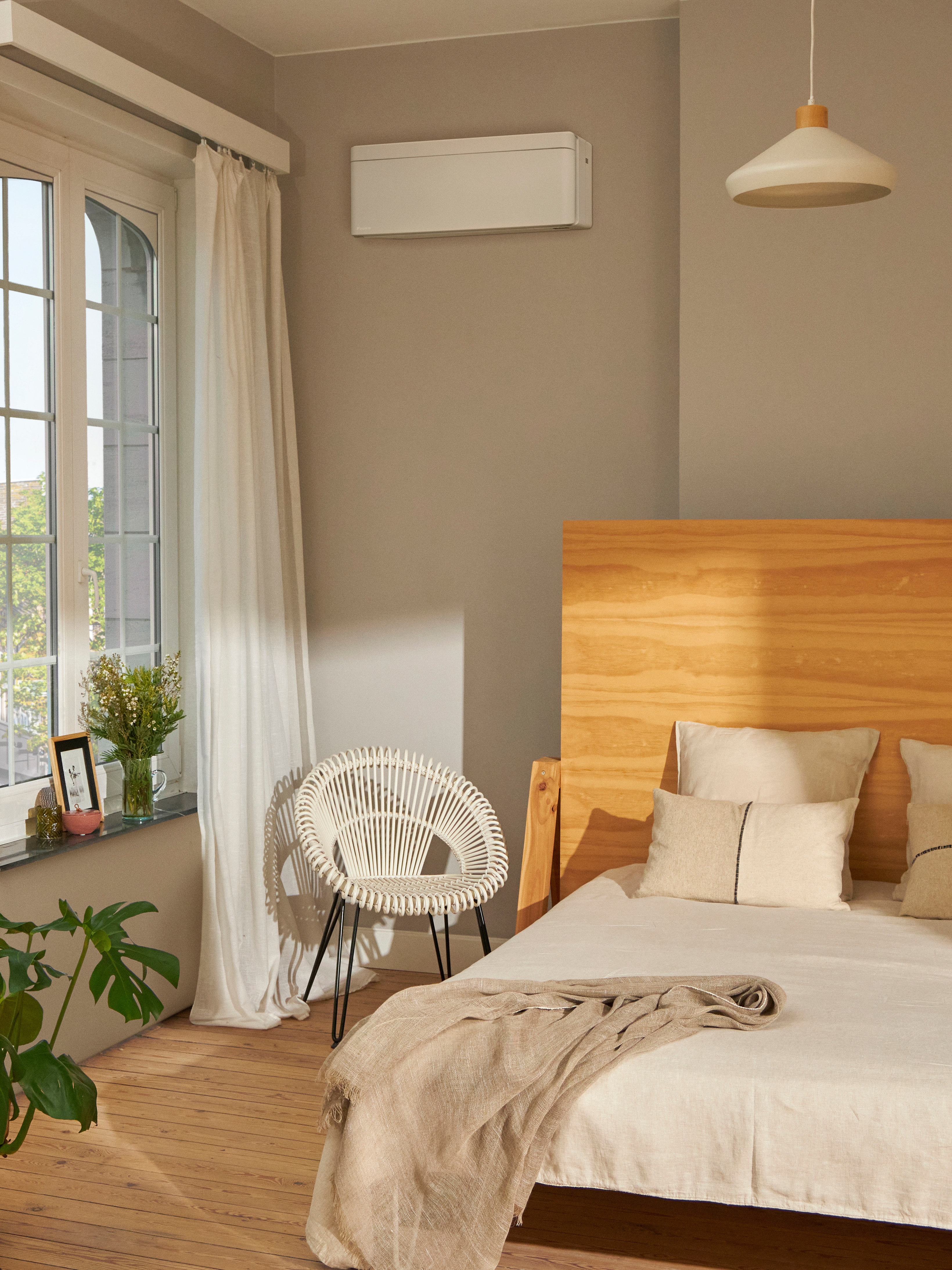 White room with computer desk next to a a big window and a wall-mounted heating solution