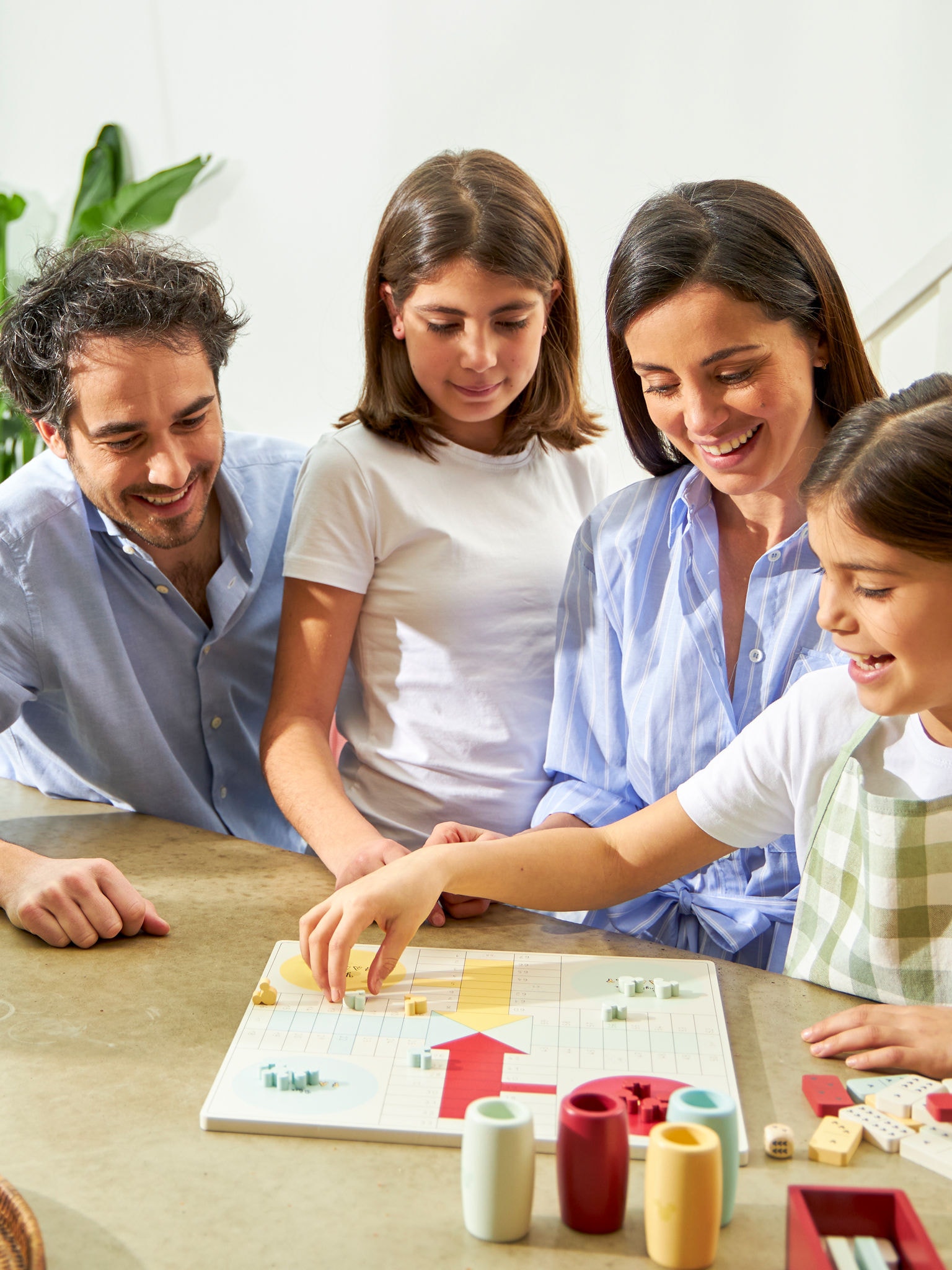 Family of four playing a board game together