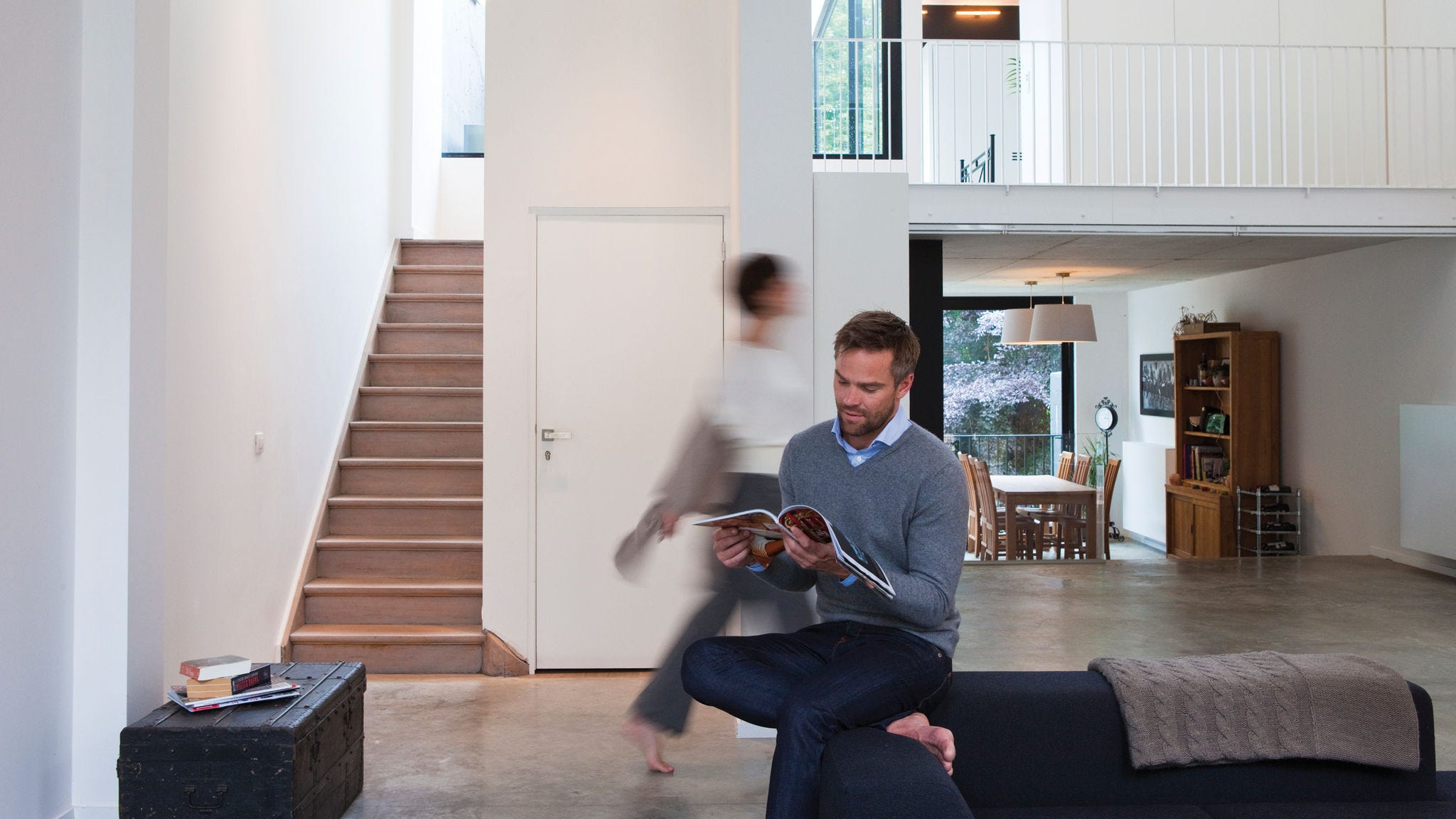 Man reading a magazine in his living room that has perfect temperature