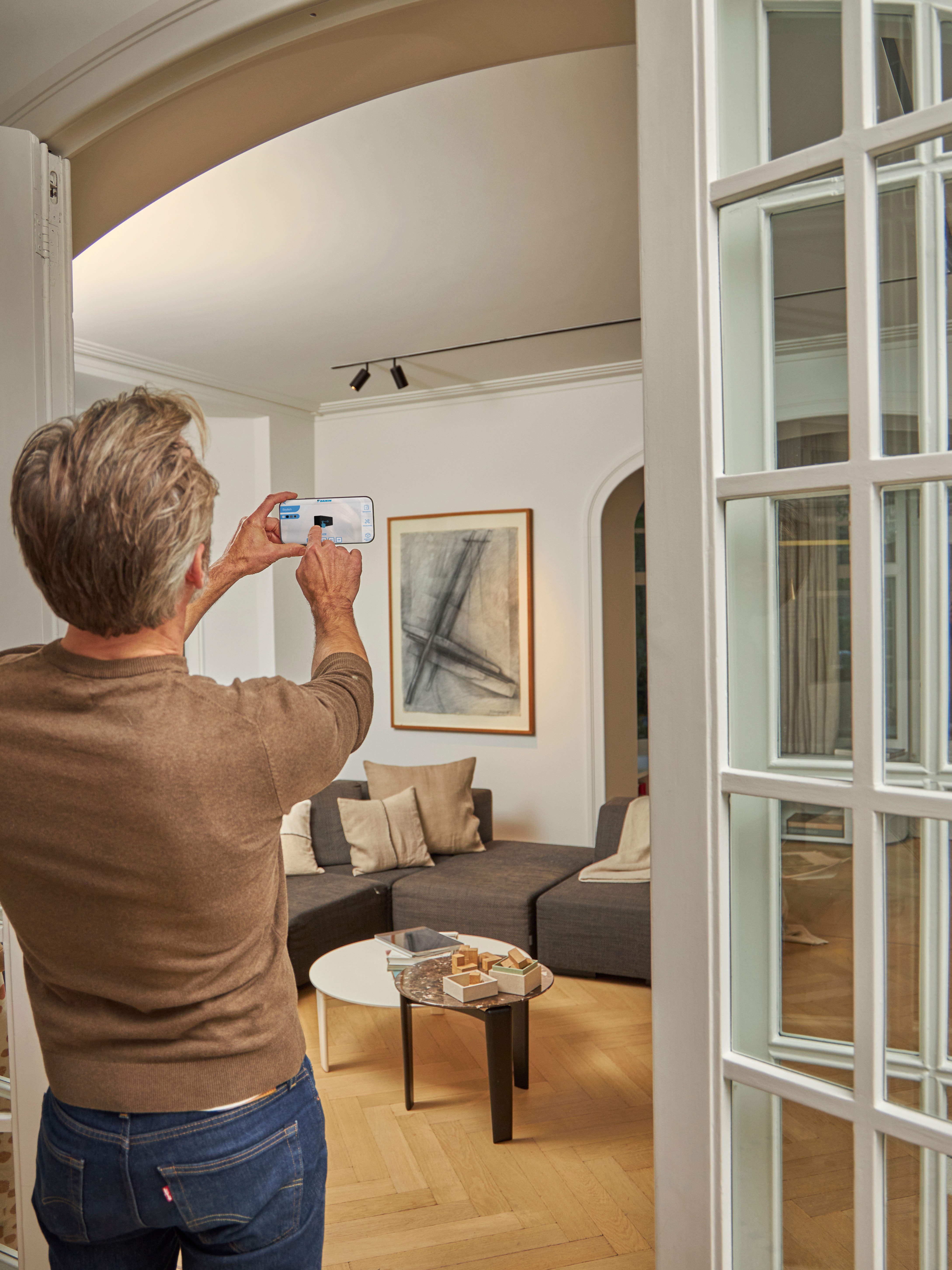 Man using the 3D app with augmented reality air-to-air heat pumps to visualize the units with the interior and exterior design