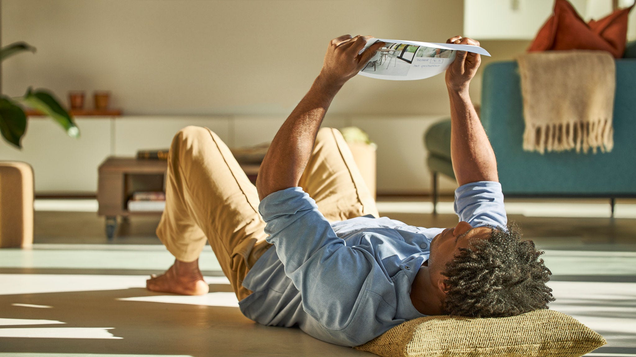Man lying down looking at a plan for heat pump installation