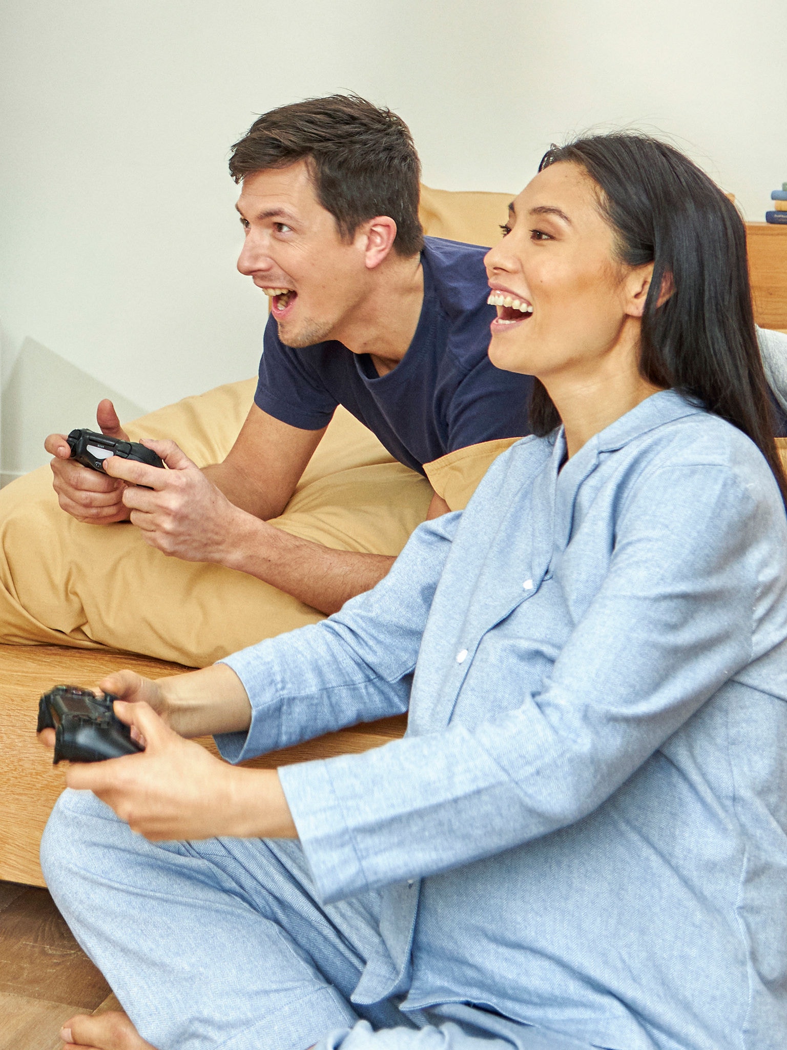 Couple gaming in sleepwear enjoying a ventilated home