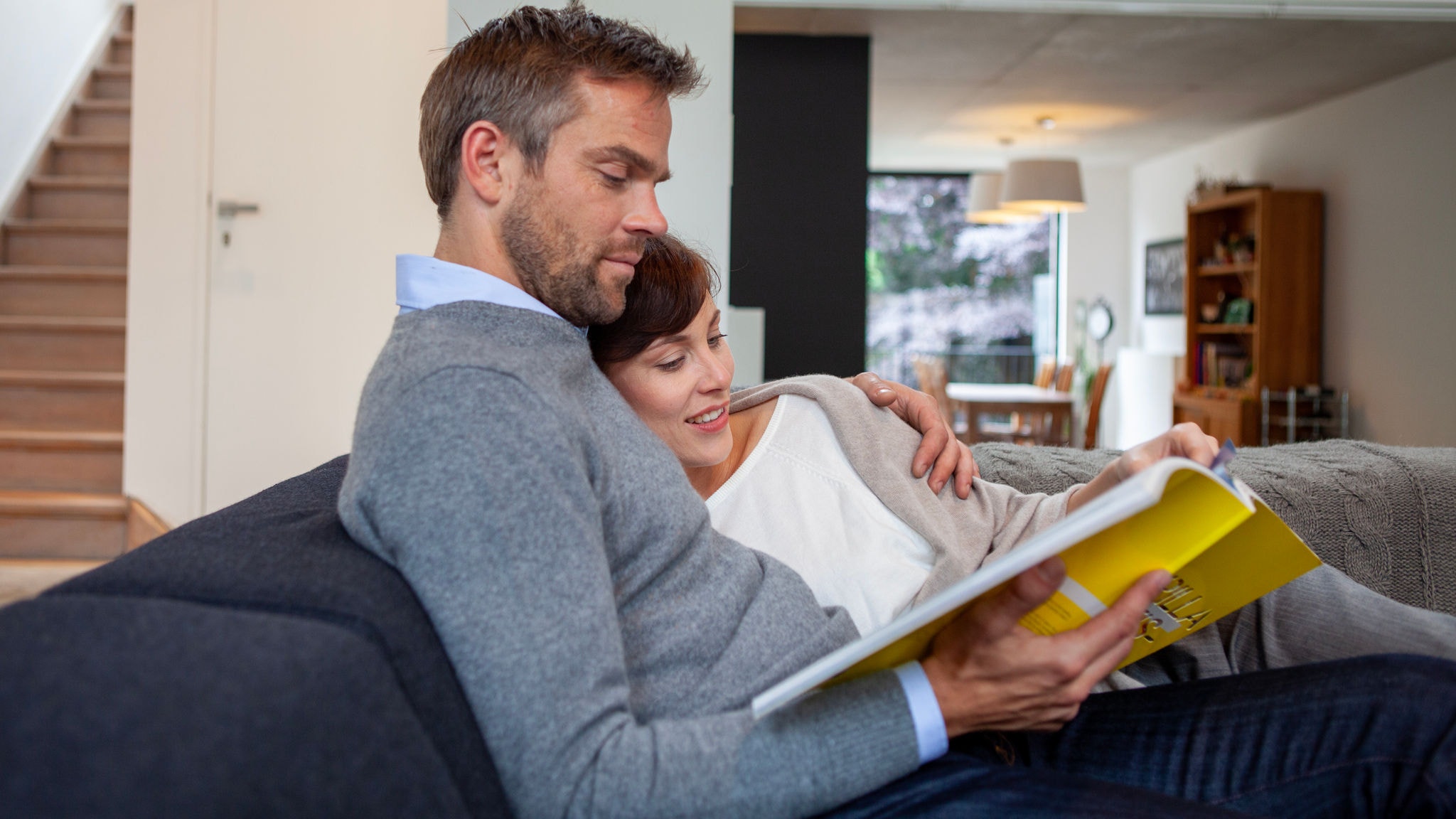 Couple relaxing indoors and reading while relying on the perfect temperature thanks to the Stylish air conditioner