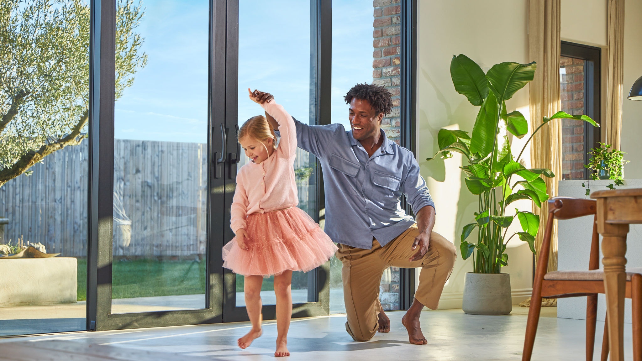 Father and daughter dancing on bare feet on a warm floor thanks to underfloor heating