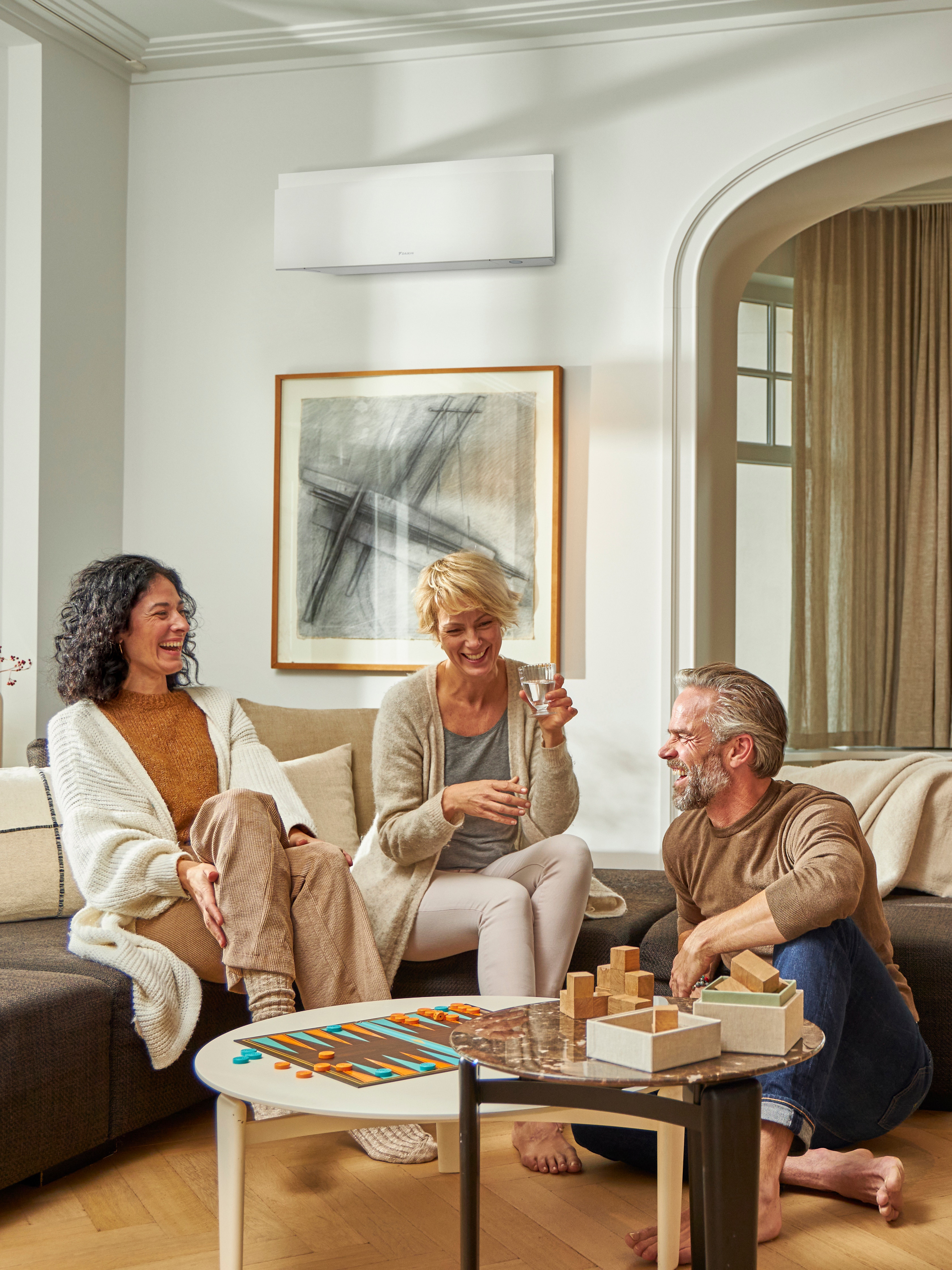 Three friends happily playing a board game in perfect temperature