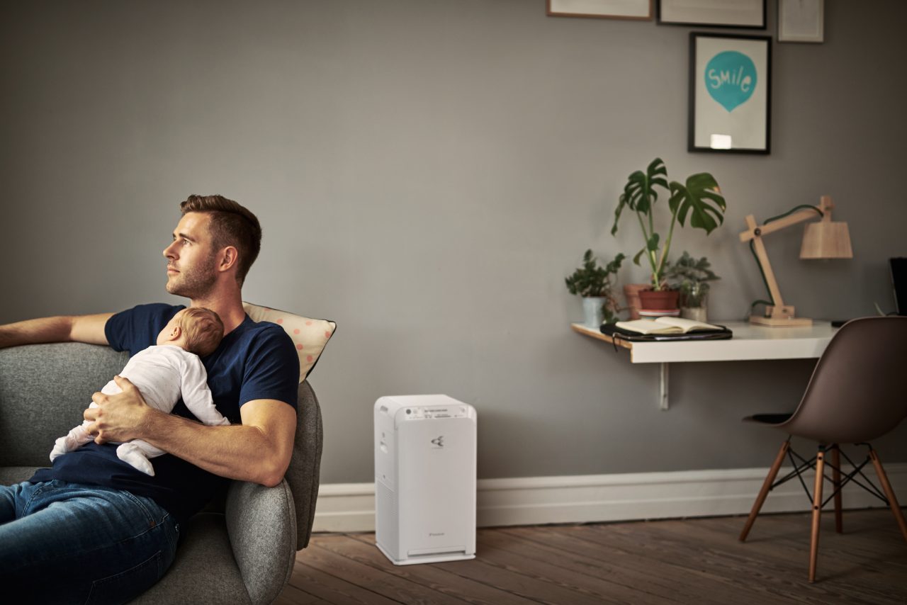 Homeower using the Onecta app to control her air purifier to purify the air inside.