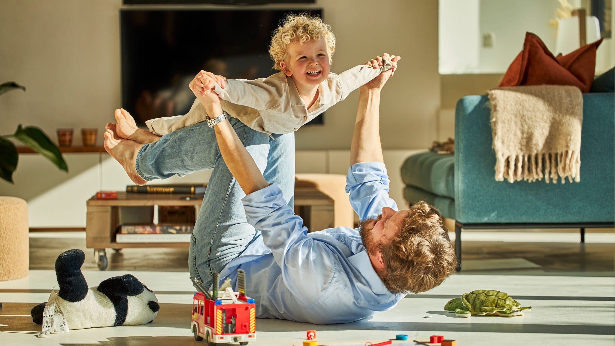 Dad and his child happily playing together and enjoying the warmth of underfloor heating