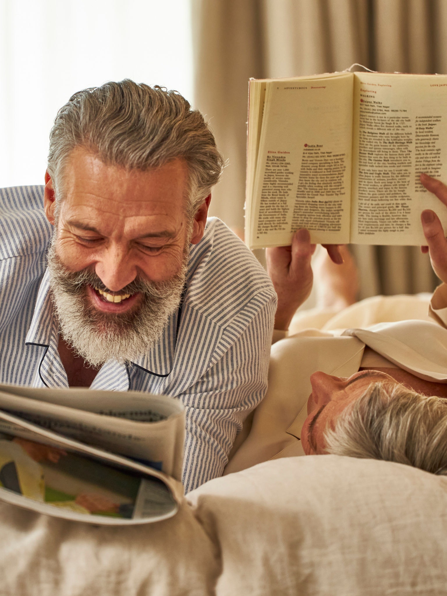 Middle-aged couple relaxing and reading in the bedroom that has good air quality